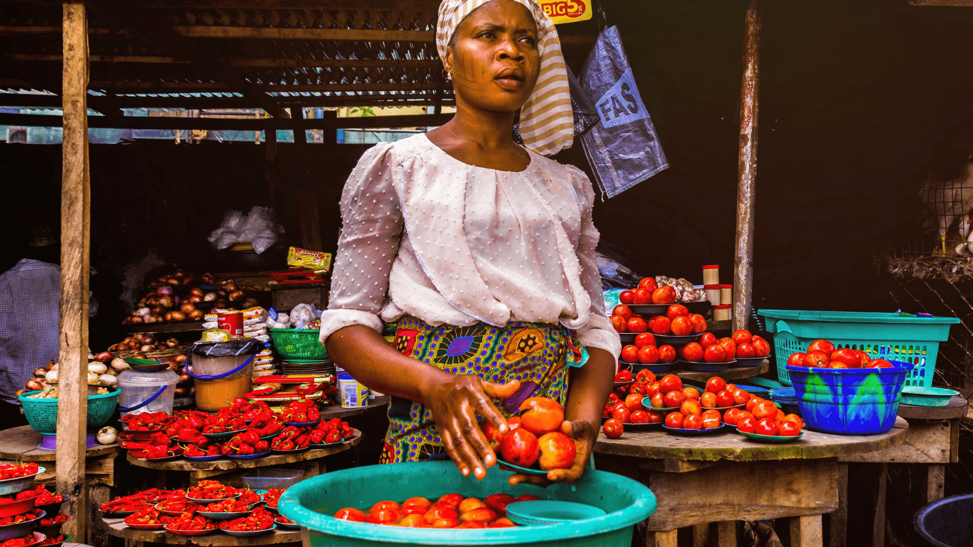 Woman holding tomatoes at a fresh vegetable market
